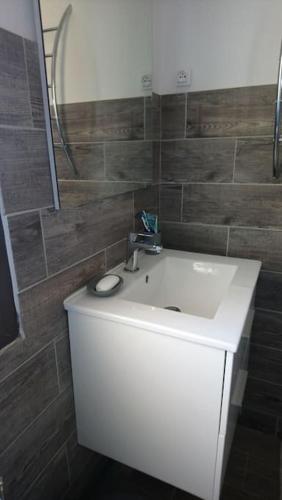 une salle de bain avec un lavabo blanc et un miroir dans l'établissement Studio climatisé tout confort à 100 m de la plage, à Lumio