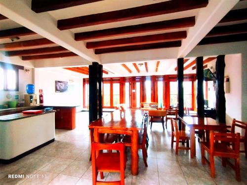 uma cozinha e sala de jantar com mesas e cadeiras de madeira em Hostal GalaHouse em Puerto Ayora