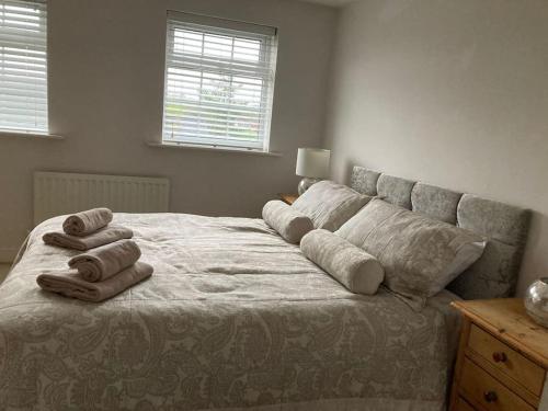 1 cama con 4 almohadas en el dormitorio en Guest Homes - Hunters Wood Court en Euxton