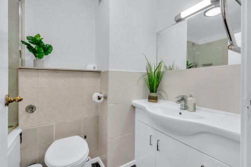 a white bathroom with a toilet and a sink at Mansion House Flat by MySquare in London