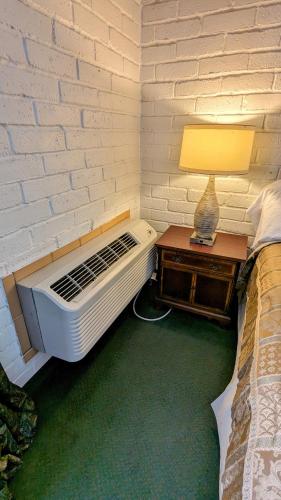 a bedroom with a bed and a white brick wall at Edelweiss Inn New Braunfels in New Braunfels