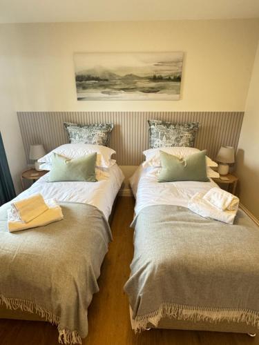 two beds sitting next to each other in a room at Island View - Spacious Two Bedroom Oban Apartment with Sea Views in Oban