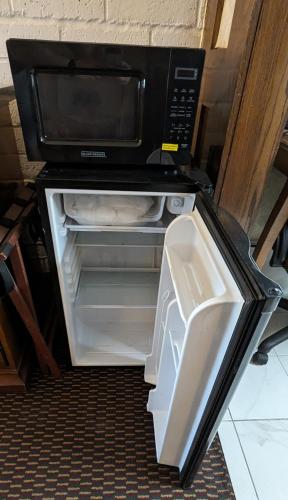 an open refrigerator with a microwave on top of it at Edelweiss Inn New Braunfels in New Braunfels