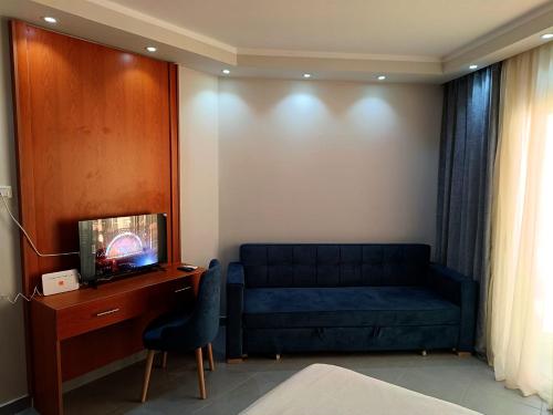 uma sala de estar com um sofá azul e uma secretária em Scandic Resort Apartment B604 Hurghada em Hurghada