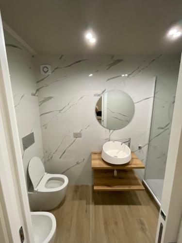 a bathroom with a toilet and a sink and a mirror at Élite Etnea in Catania