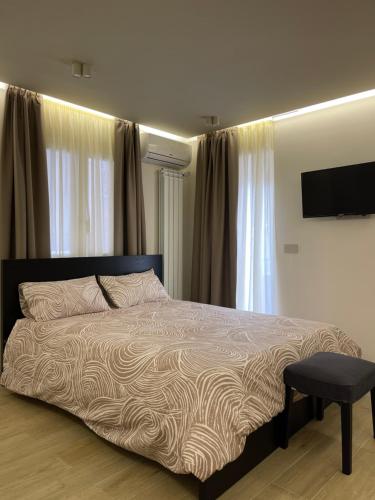 a bedroom with a bed with a television and a chair at Élite Etnea in Catania