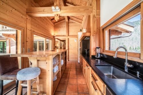 a kitchen with a counter and a sink in a log cabin at Chalet L'aube claire - 5 étoiles in Morzine