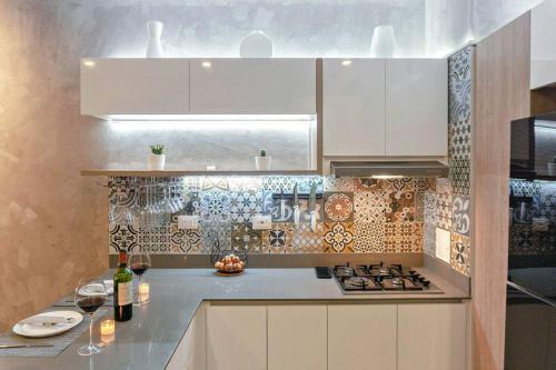 a kitchen with white cabinets and a stove top oven at Moderno Apartasuite en Gaira in Santa Marta