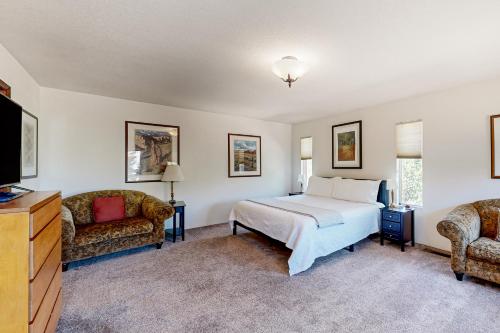 a bedroom with a bed and two chairs and a television at Rockridge in Sedona