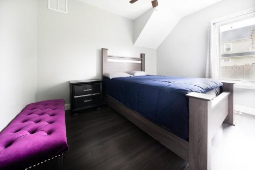 a bedroom with a purple bed and a window at The Maid of the Mist Villa- With Private Yard & Parking, Minutes From Falls & Casino by Niagara Hospitality in Niagara Falls