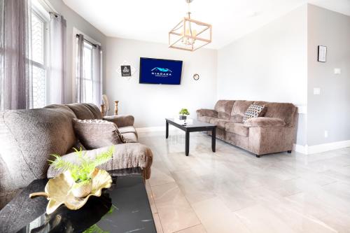 a living room with two couches and a table at Large-Group Ready 8BR Home Near Niagara Falls & Casino in Niagara Falls