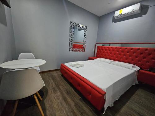 a bedroom with a red bed and a table and chair at RESIDENCIAL LA MALVARROSA in Panama City