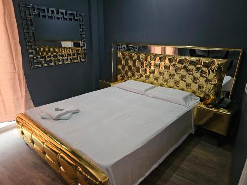 Bett mit einem goldenen Kopfteil und einem Spiegel in der Unterkunft RESIDENCIAL LA MALVARROSA in Panama-Stadt