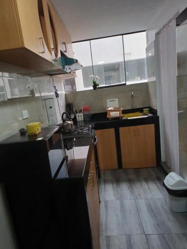 uma pequena cozinha com um lavatório e um fogão em Lucia's apartmens em Cusco