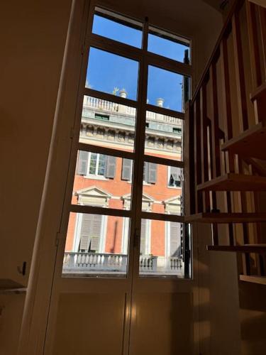 - une porte offrant une vue sur un bâtiment depuis une fenêtre dans l'établissement New apartment with balcony, à Gênes