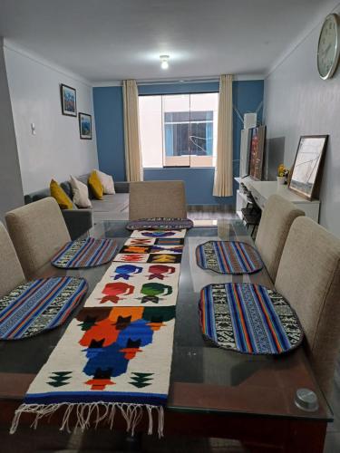 uma sala de estar com uma mesa com tapetes coloridos em Lucia's apartmens em Cusco