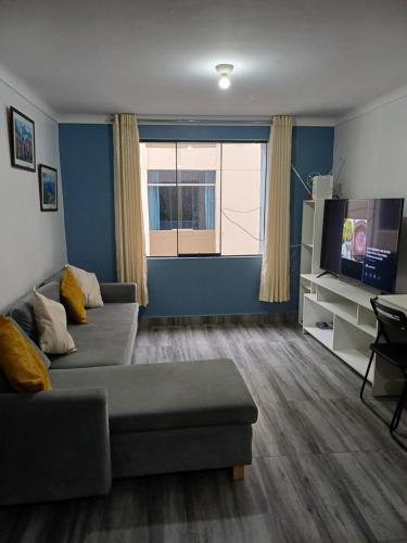 uma sala de estar com um sofá e uma televisão em Lucia's apartmens em Cusco