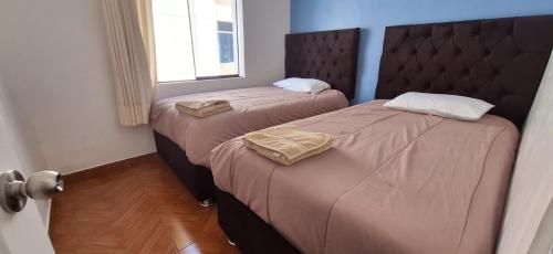 2 camas individuais num quarto com uma janela em Lucia's apartmens em Cusco