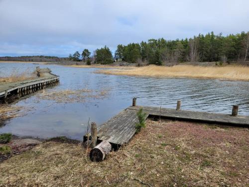 a wooden dock next to a body of water at Bastöstugby stuga 16 in Pålsböle