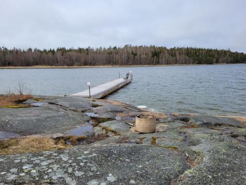 a dock on a lake with a body of water at Bastöstugby stuga 16 in Pålsböle