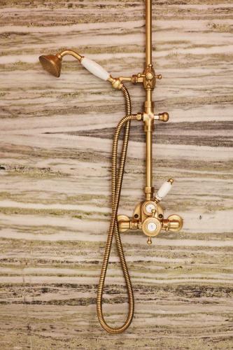 une pomme de douche en or suspendue sur un mur dans l'établissement FONDATION CAB St-Paul-de-Vence, à Saint-Paul-de-Vence