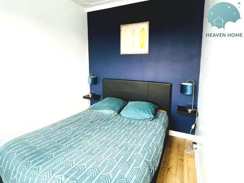 a bedroom with a bed with a blue wall at Charmant appartement proche des commerces et Gare in Saint-Brieuc