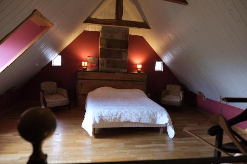 une chambre avec un lit blanc dans un grenier dans l'établissement Les hirondelles, à Saint-Bonnet-la-Rivière