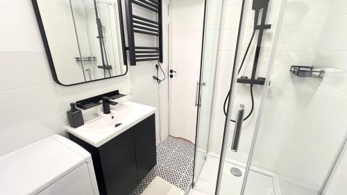 uma casa de banho com um lavatório e um chuveiro em Prestige Apartments - Orłowska 40 - Studio em Gdynia