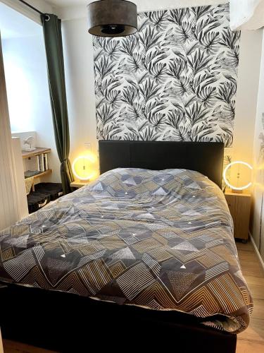 a bedroom with a bed with a black and white blanket at Magnifique T2 coeur de ville Port a pieds in Paimpol