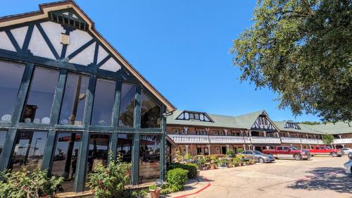 a building with large windows in a parking lot at Edelweiss Inn New Braunfels in New Braunfels