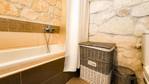 ein Badezimmer mit Badewanne und einem Korb neben der Dusche in der Unterkunft Maria's stone Heaven Retreat in Kalandra