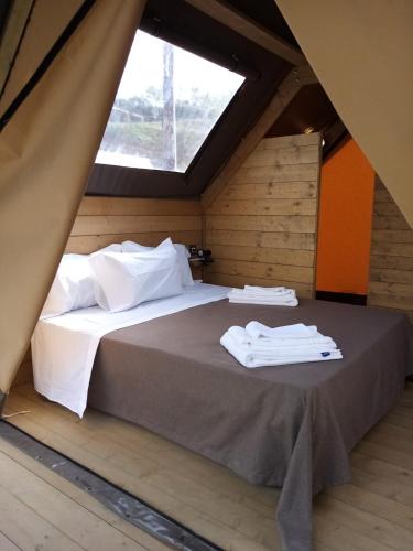 un grande letto in una stanza con finestra di Glamping - La Giara a San Demetrio Corone