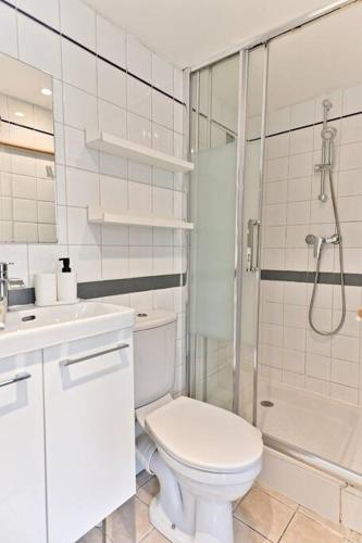 une salle de bain blanche avec toilettes et douche dans l'établissement Appartement paisible et central Rivoli, à Paris