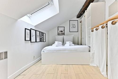- une chambre blanche avec un lit dans l'établissement Appartement paisible et central Rivoli, à Paris
