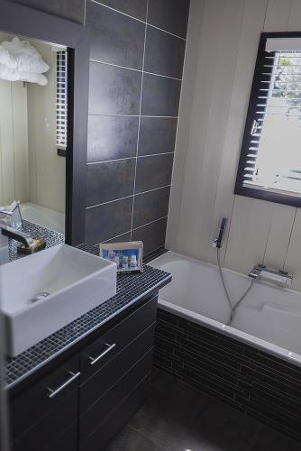 une salle de bain avec un lavabo et une baignoire dans l'établissement Le Moulin des Sables, à La Flotte