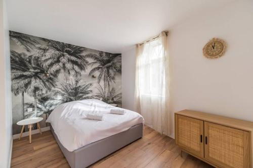 a bedroom with a bed with a tropical wallpaper at Elegant appartement 2chambres Cote de Granit Rose in Pleumeur-Bodou