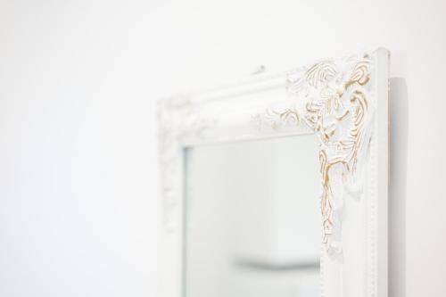 a white door with a mirror in a room at City Center Hideout - Studio Apartment in Tirana