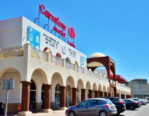 a building with cars parked in front of it at A 2 pas de la plage, appartement cosy, confort, proche toutes commodités, Wifi haut débit, TV connectée, Netflix, climatiseur, Acte mariage pour couple national,3 nuits mimum in El Jadida