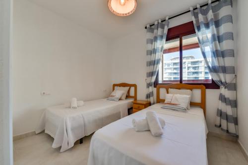 Duas camas num quarto com uma janela em Apartment Beachfront 36 em Calpe