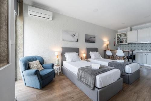 a bedroom with two beds and a couch and a chair at GuestReady - Maria d'Afurada in Vila Nova de Gaia