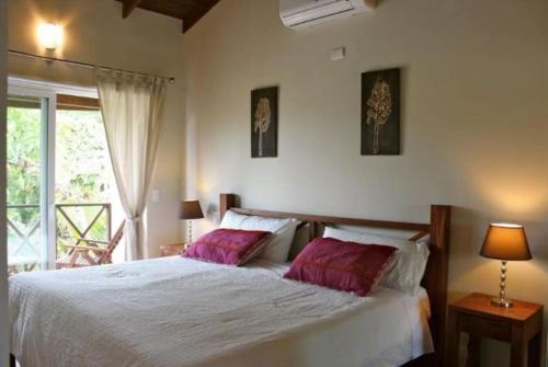 a bedroom with a bed with two pink pillows at Escalonia 2 in Las Terrenas