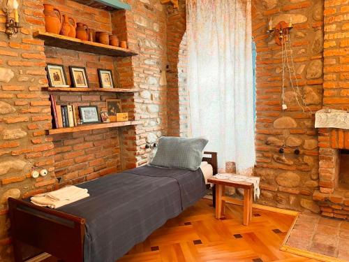 a bedroom with a bed in a brick wall at Dabakhnebi in Telavi