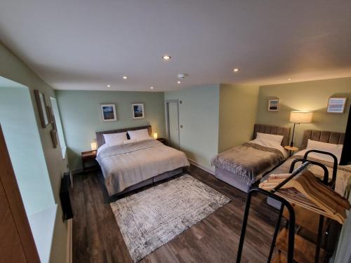 a bedroom with two beds and a rug at Harlech House in Harlech