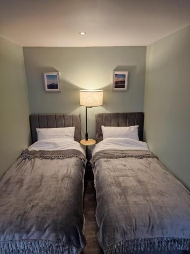 two beds sitting next to each other in a room at Harlech House in Harlech