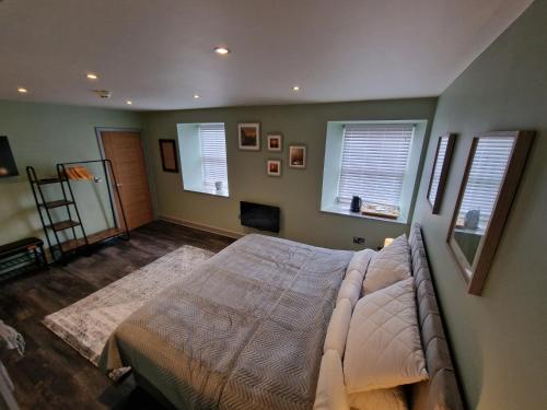 a bedroom with a bed and two windows at Harlech House in Harlech
