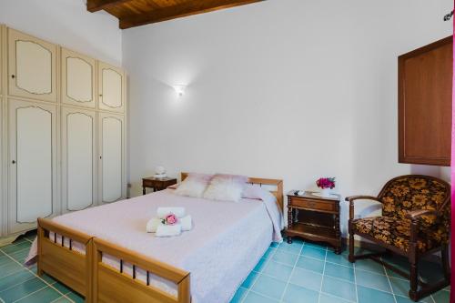 a bedroom with a bed and a chair at Il Corbezzolo Apartment in Palmas Arborea