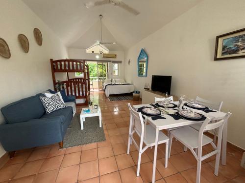 Una sala de estar con una mesa y un sofá azul. en Apartamento en Juan Dolio, en Juan Dolio