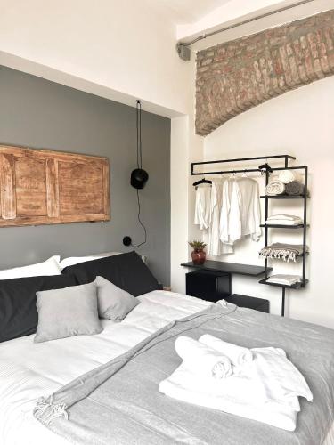 a bedroom with a bed with white sheets and towels at Loft G Hospitality in Milan