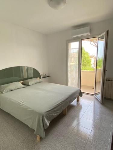 - une chambre avec un grand lit et une porte coulissante en verre dans l'établissement Appena fuori, à Misano Adriatico