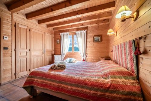 モルジヌにあるChalet L'arba clar - 4 étoilesの丸太小屋のベッドのある寝室